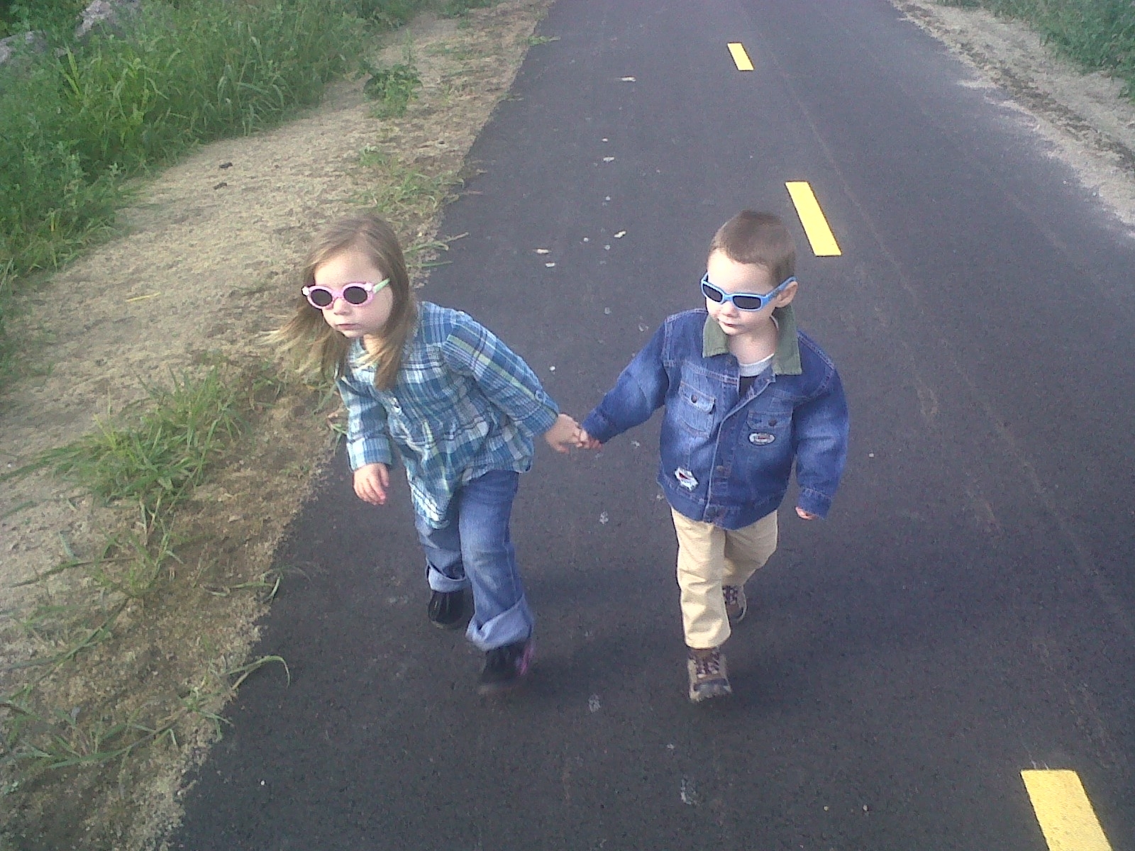 Two young children walking hand in hand on the rail trail